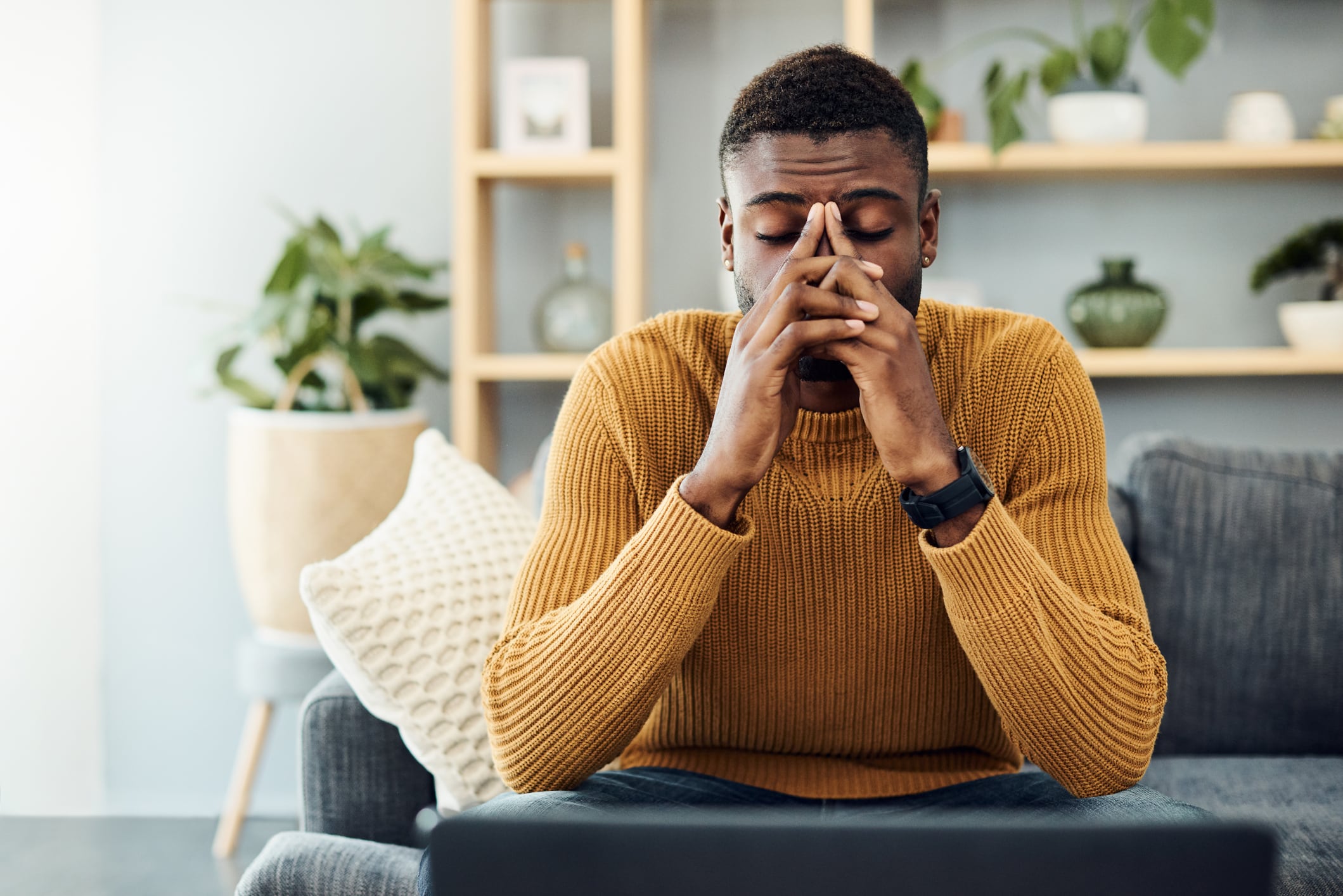 Shot of a young man looking stressed out at home with a migrane