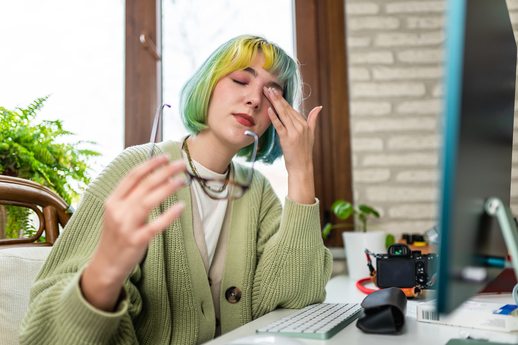 Young gen z woman has sore eyes from using computer, stressful situations