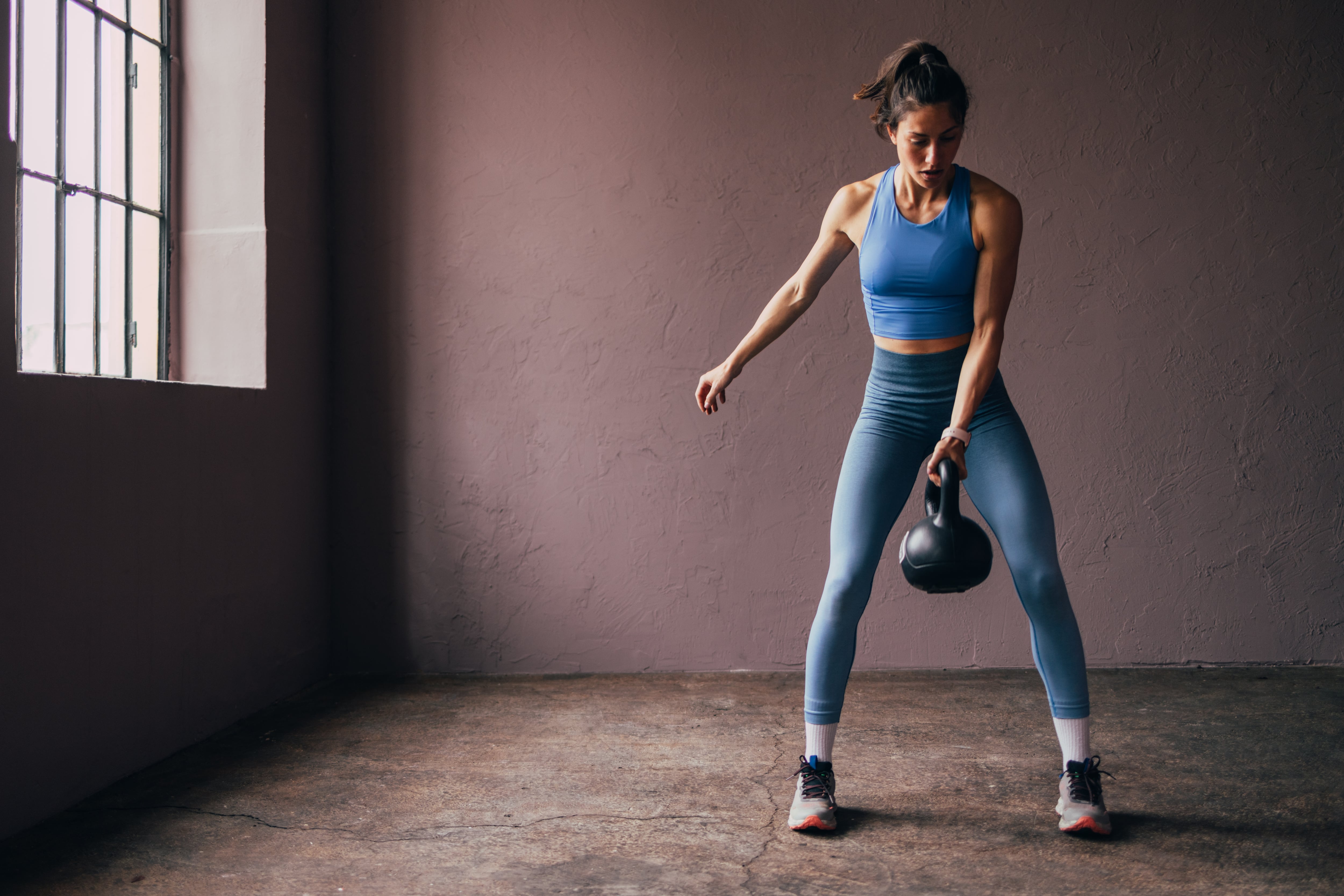 Athletic woman lifting a kettlebell