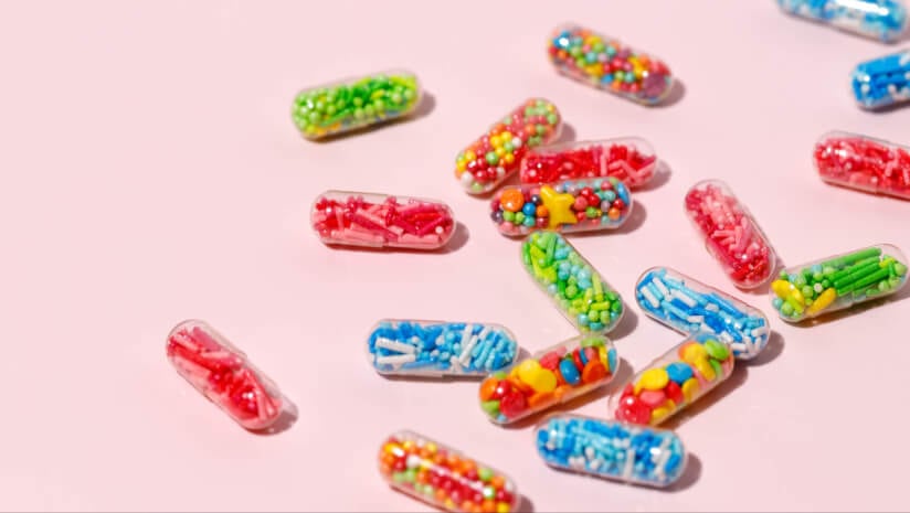 Capsules filled with colorful sugar sprinkles, creative concept