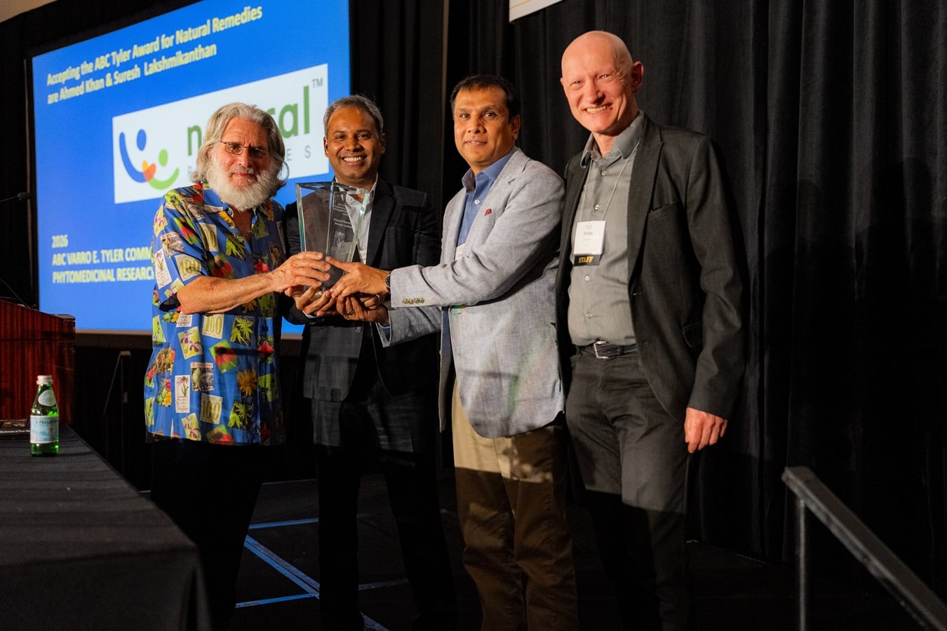 Natural Remedies' Suresh Lakshmikanthan, PhD, (center left) and Ahmed Khan (center right) receiving the 2026 Varro E. Tyler Award for Investment in Phytomedicinal Research from Mark Blumenthal (left) and Stefan Gafner (right)