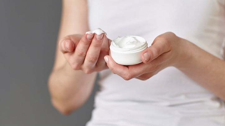 Person using cosmetic cream