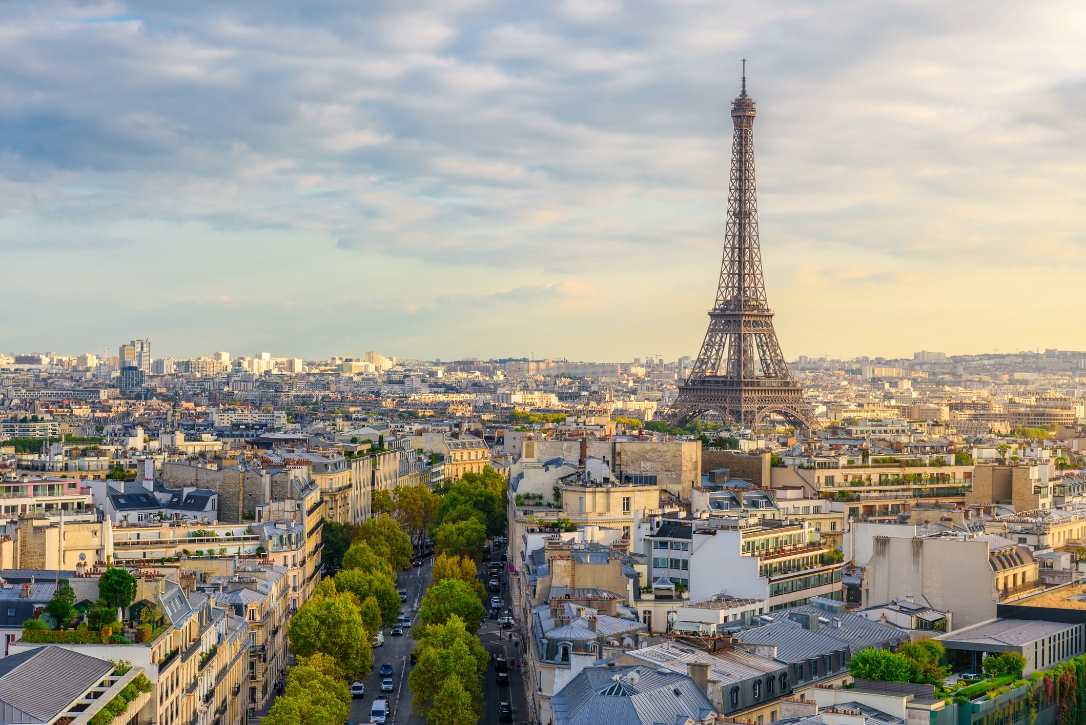 Aerial view of Paris with Eiffel Tower and Champs Elysees from the roof of the Triumphal Arch. Panoramic sunset view of old town of Paris. City skyline. Popular travel destination.