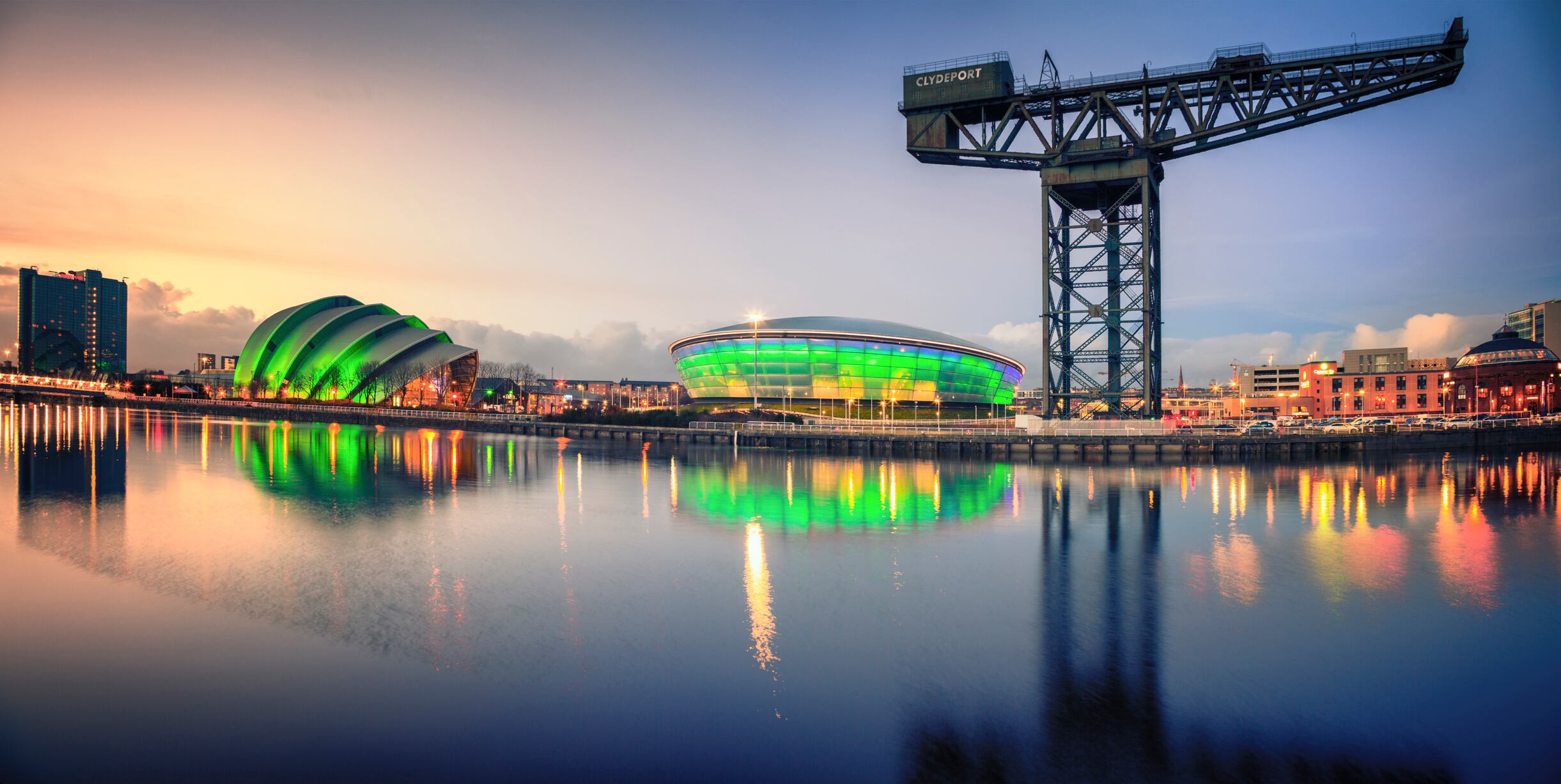 Glasgow, UK - February 6, 2014: The Scottish Exhibition and Conference Centre Clyde Auditorium (commonly known as the Armadillo) and the Scottish Hydro Arena lit up green at night and reflected in the River Clyde as it flows through Glasgow.