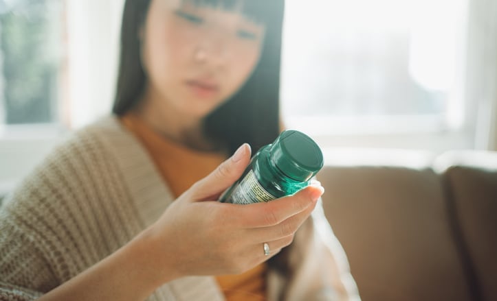 woman-looking-at-supplement-bottle.png