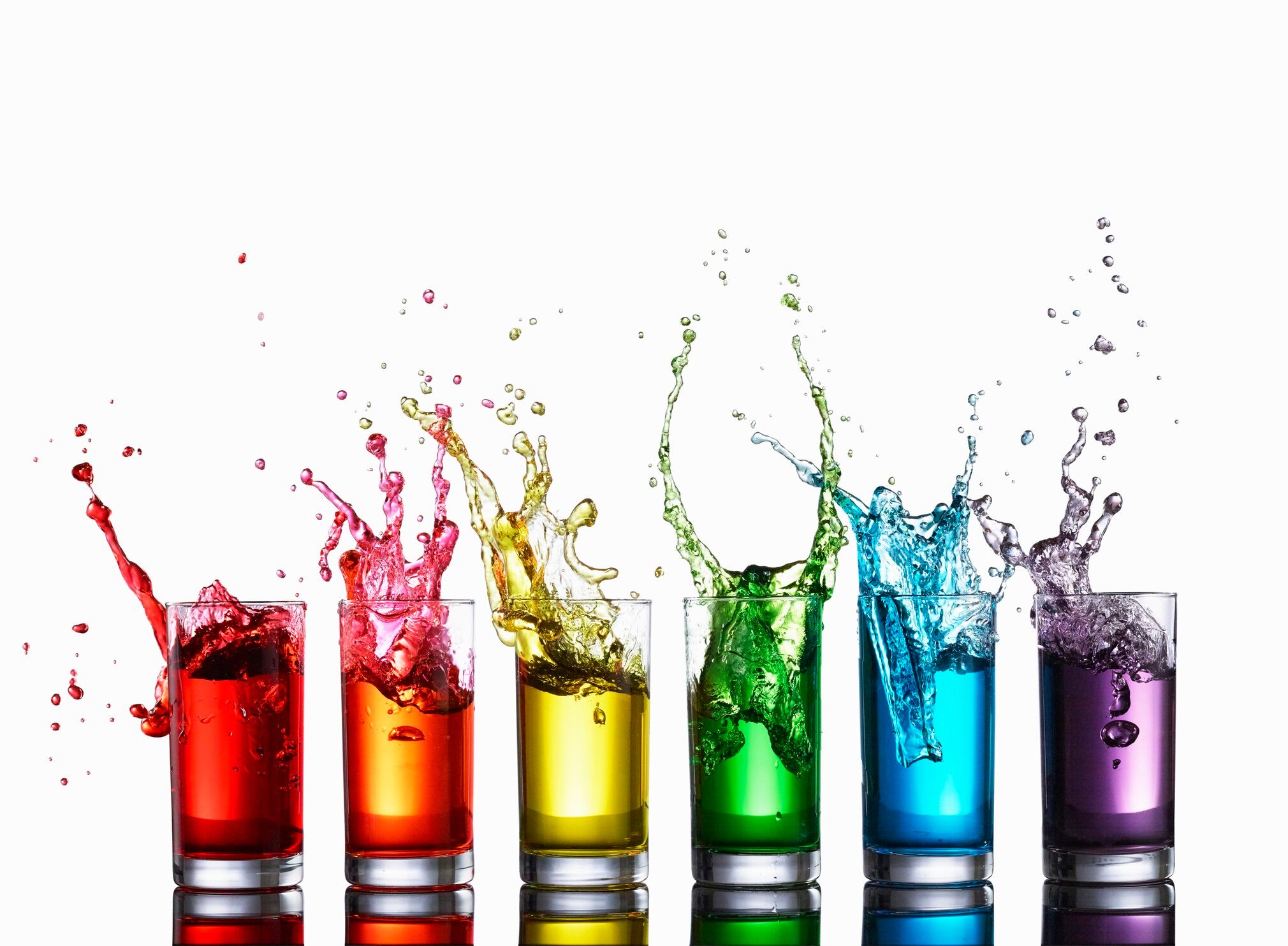 Glasses of colorful liquid splashing