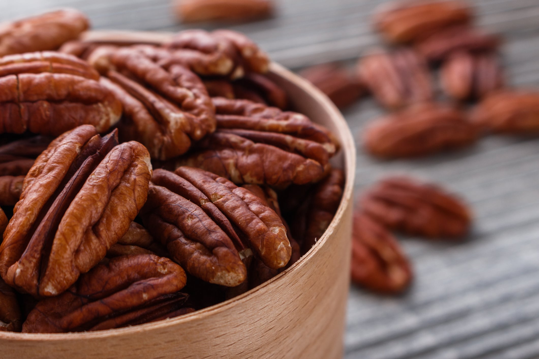 Pecan nuts on a rustic wooden background.