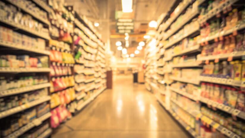 Image of blurry grocery aisle with shelves stockes with probiotics and vitamins