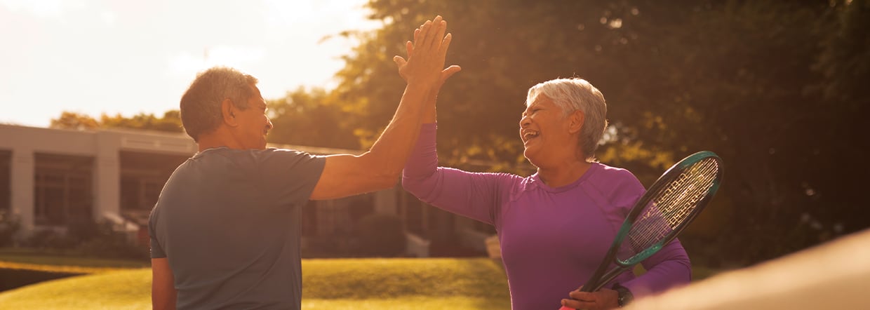 Man and woman high fiving playing tennis