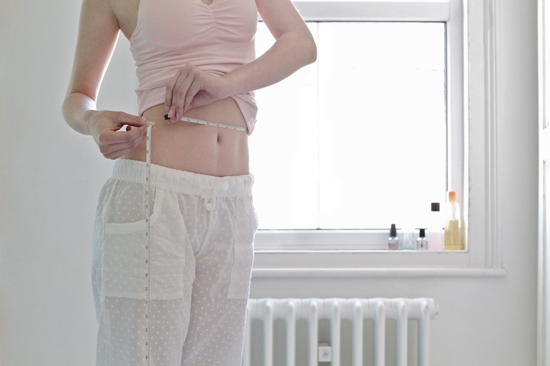 Woman measuring her waist