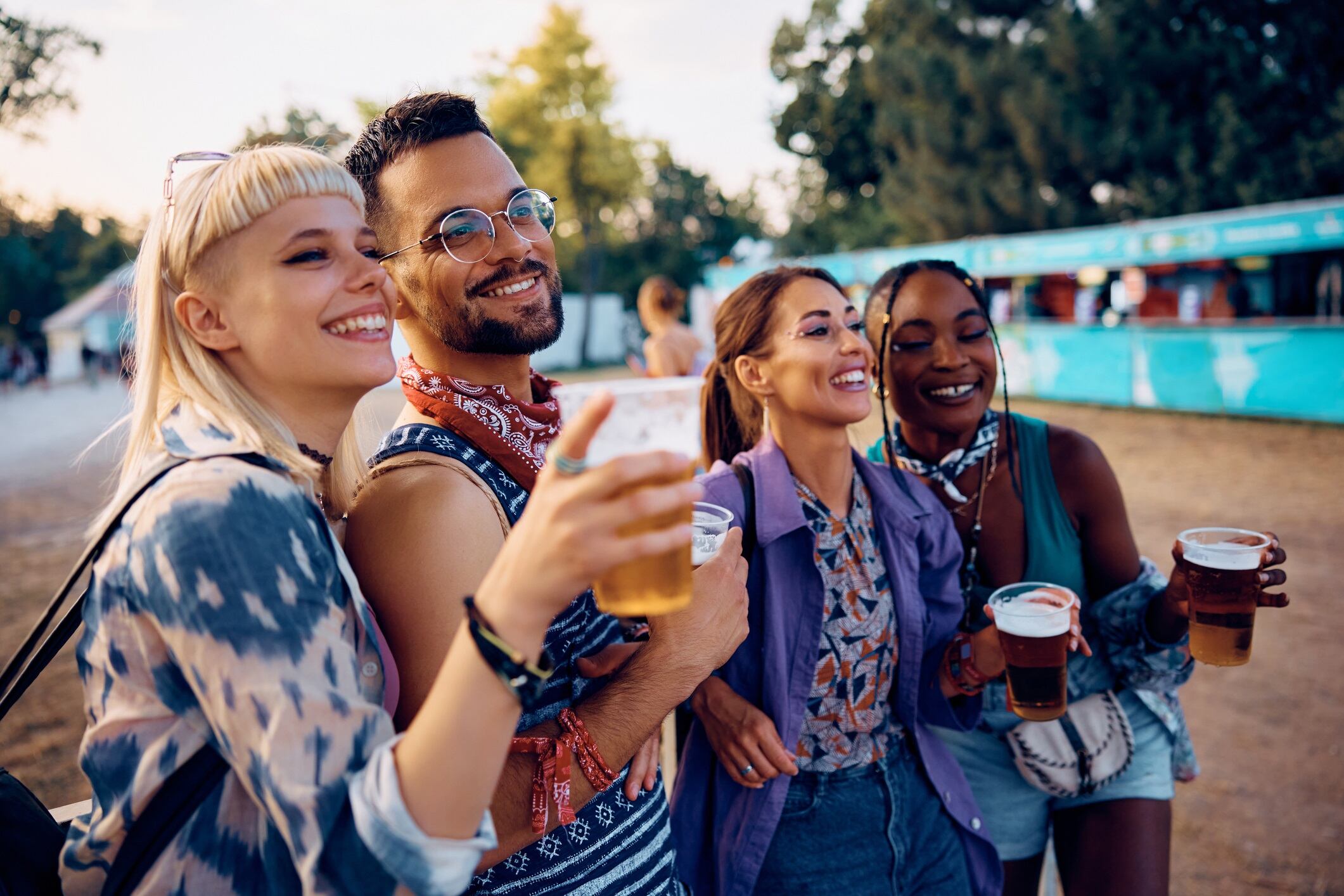 Happy man and his female friends enjoying in open air music concert in summer.