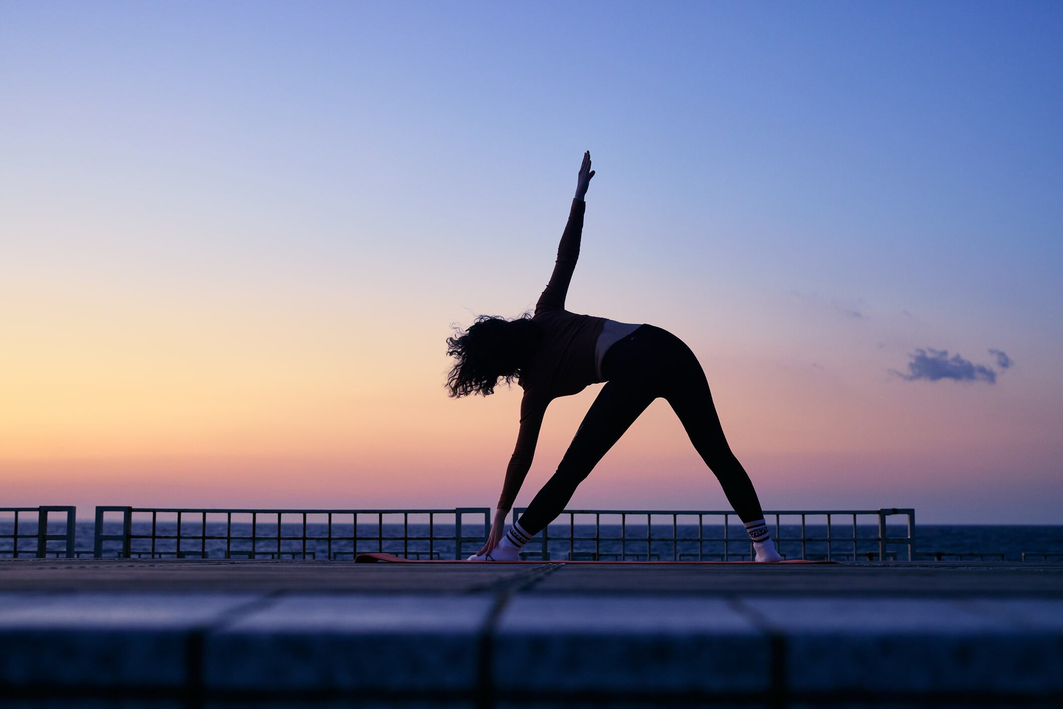 Woman exercising, sunset