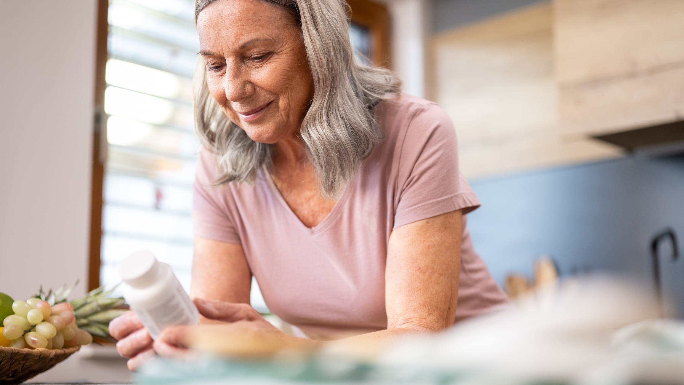 Postmenopausal woman holding pill bottle