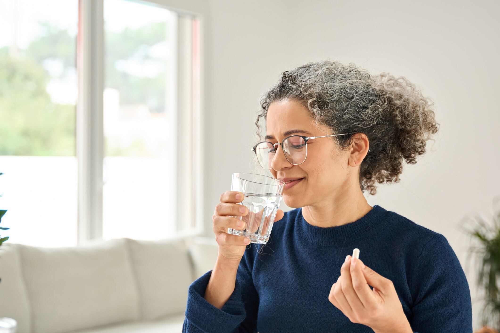 Middle aged woman taking tablet