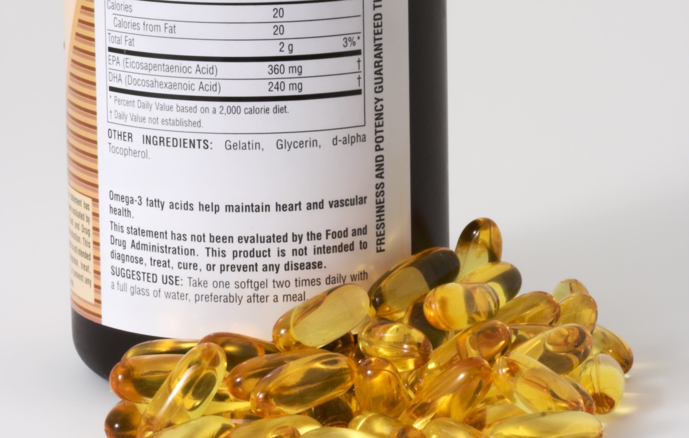 Fish oil capsules and bottle on a white background