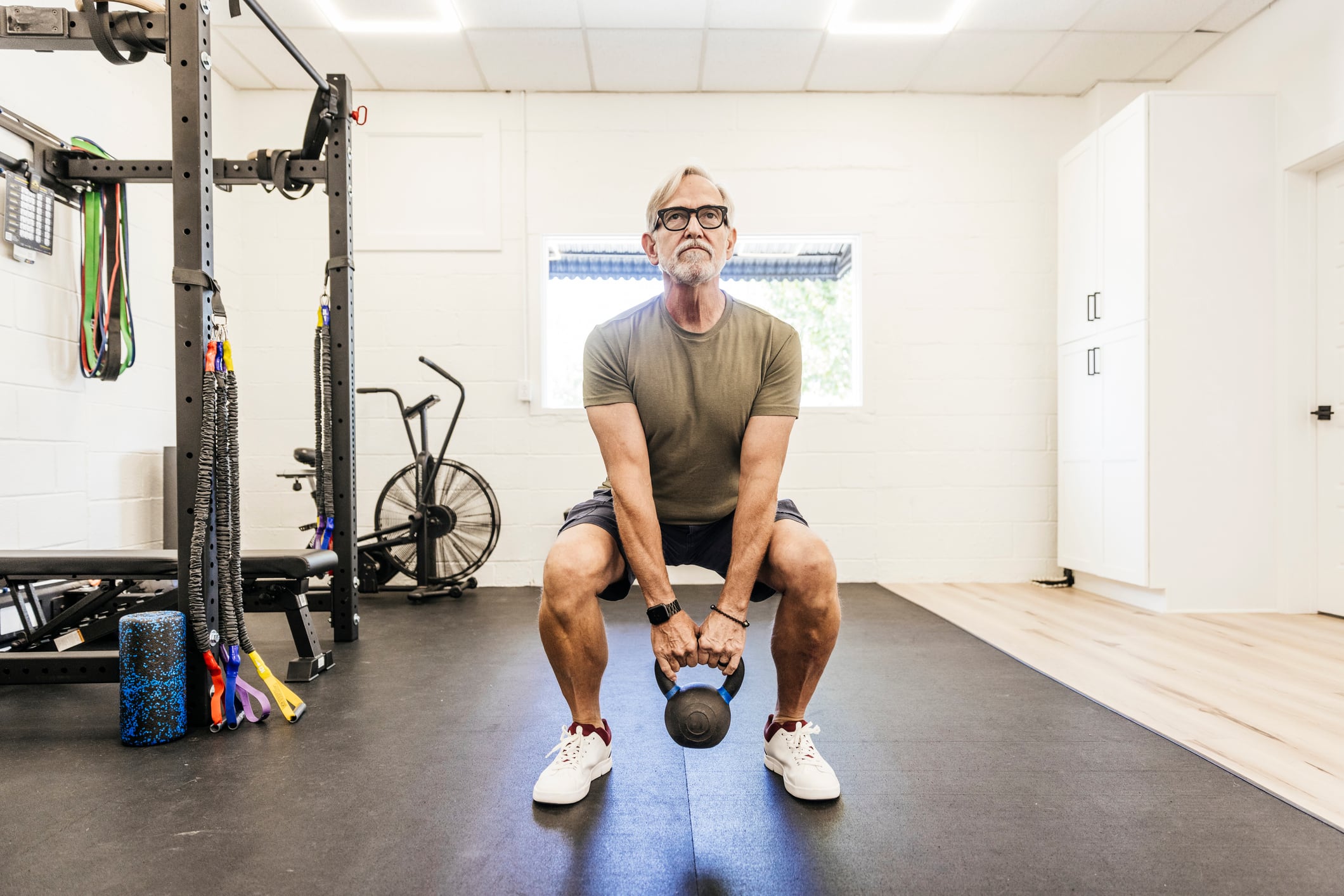 Older man lifting kettle bell