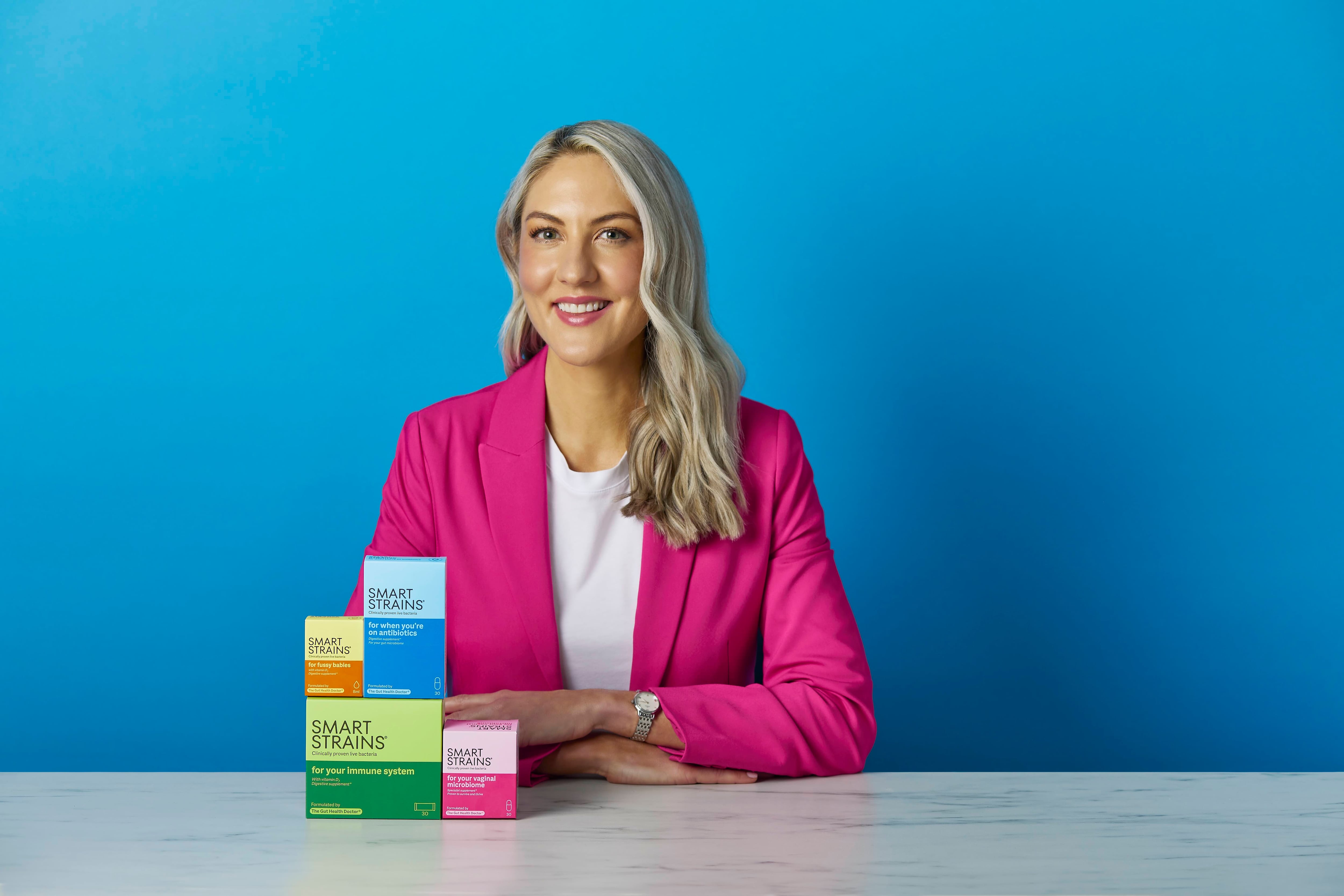 Dr. Megan Rossi sits in front of her newly launched Smart Strains probiotic range, designed to provide condition-specific solutions backed by international health guidelines.