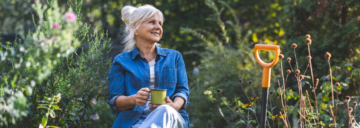 Woman sitting with a hot drink in garden