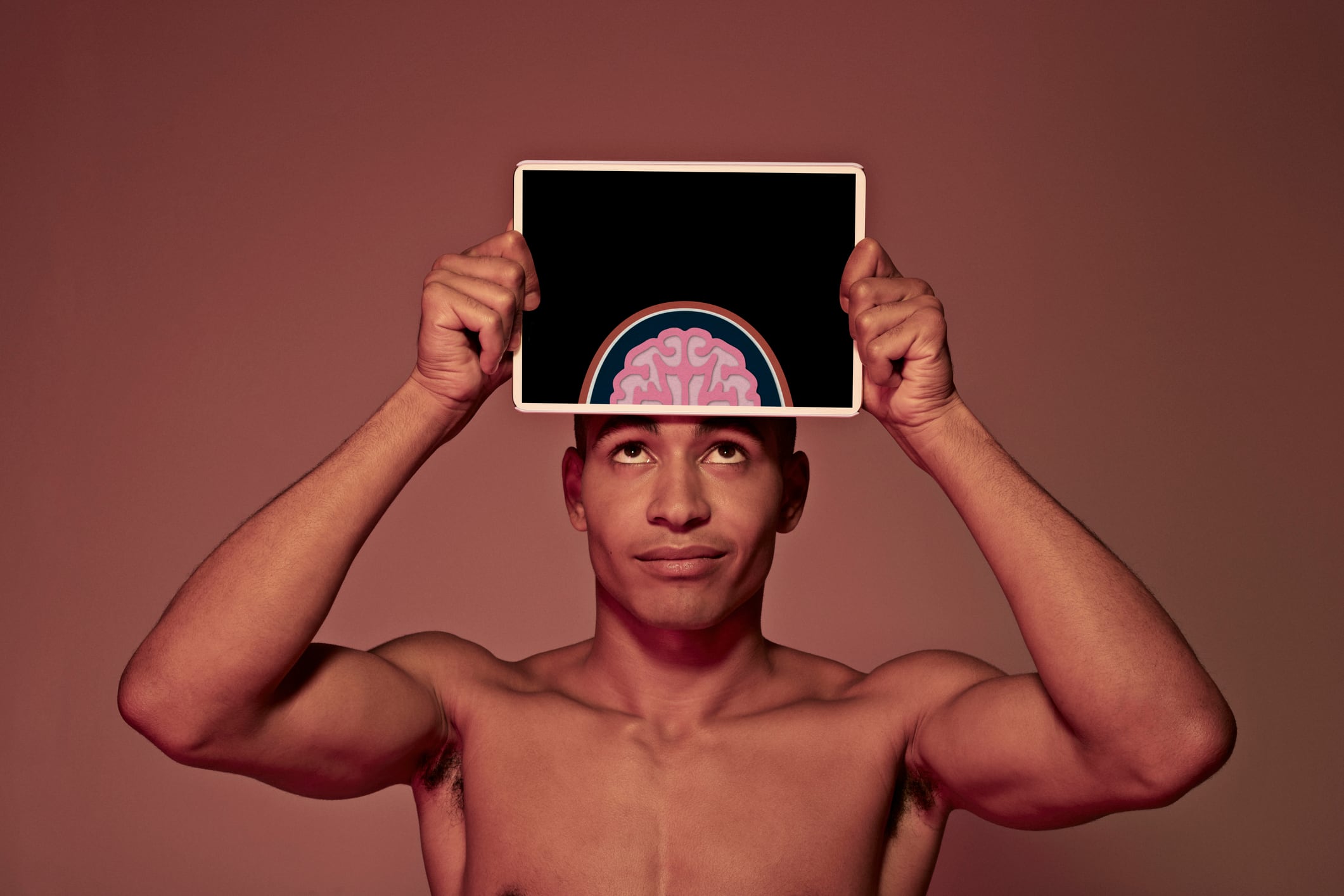 Male holding tablet in front of body to display coloured x-ray illustrations made out of hand made paper structures