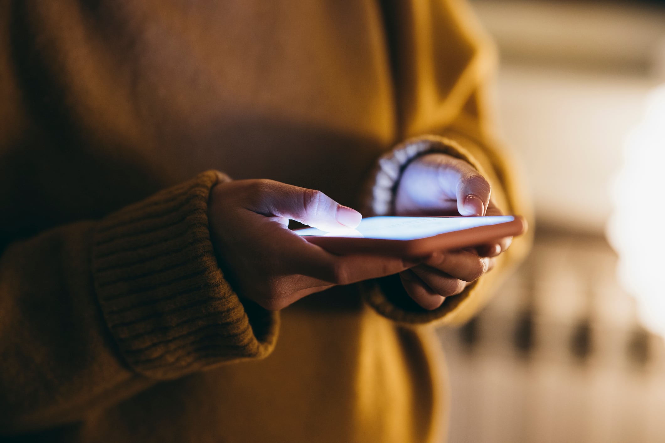 Anonymous Woman Wearing a Sweater Holding her Smartphone