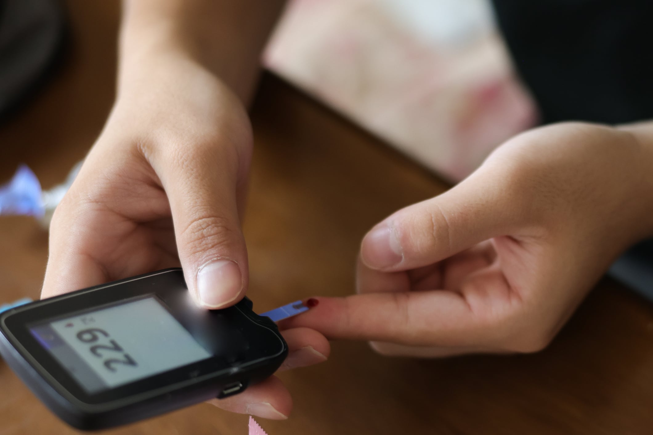 A teenager with type 1 diabetes uses an at home glucometer to test his blood sugar levels.