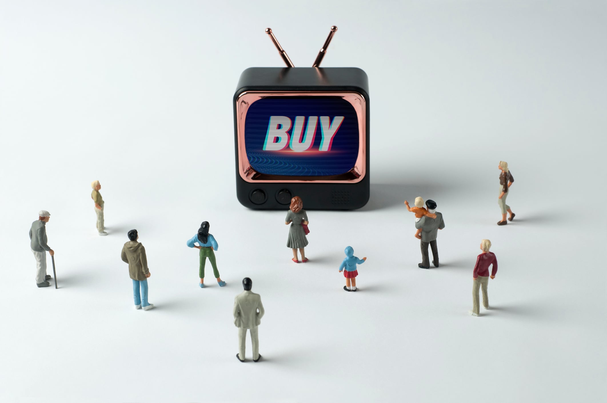 People figurines watching "Buy" instruction on TV. Post-truth concept