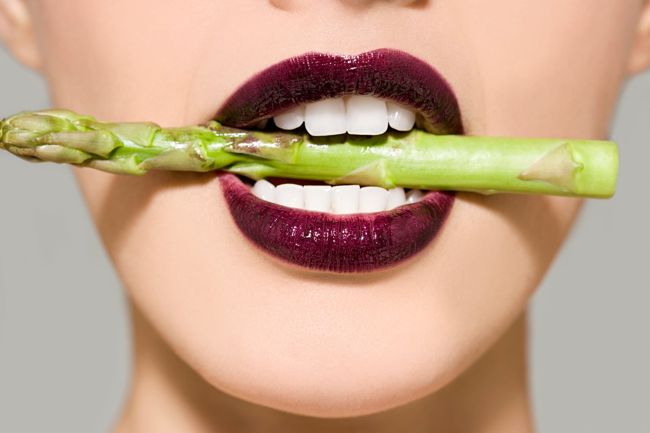 Woman with asparagus in mouth