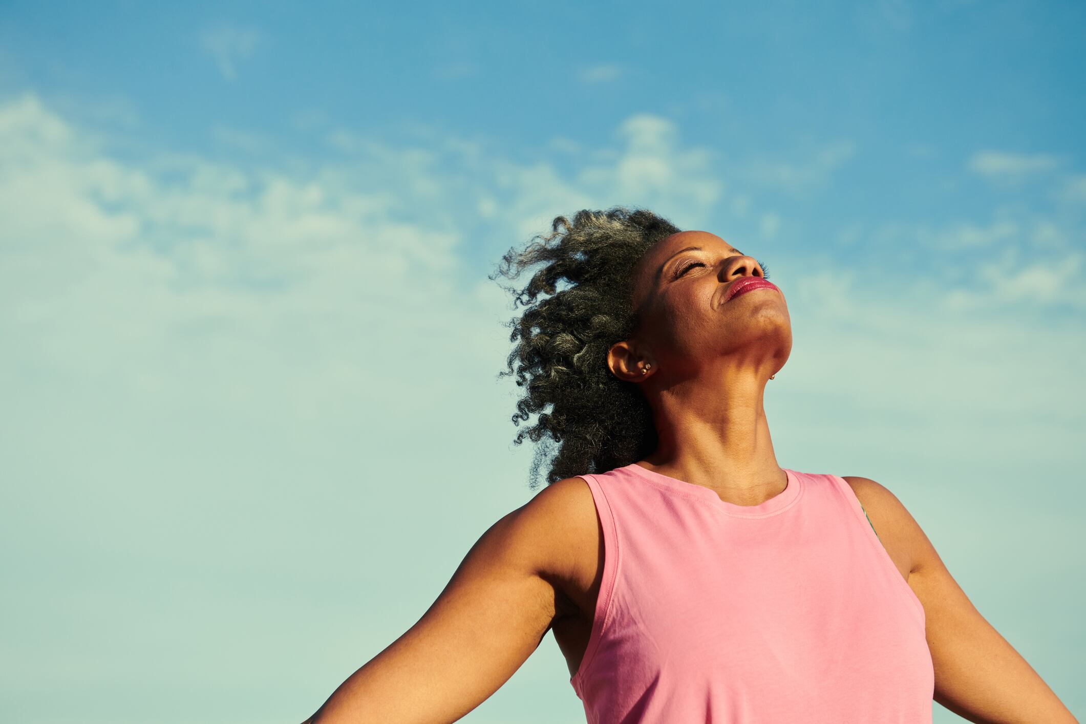 Standing on a windy beach with the sky in the background.