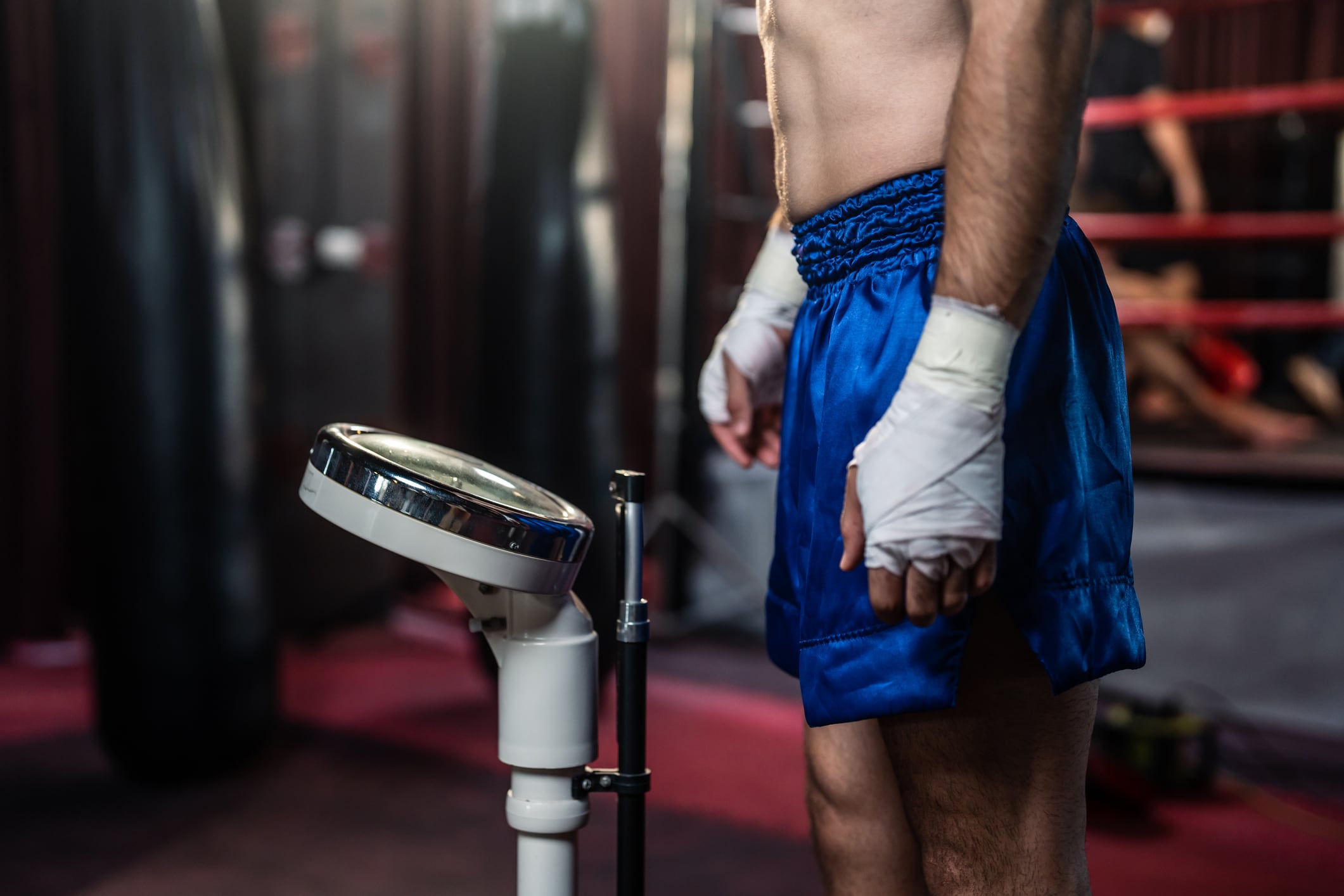 Close up of young sportsman measure weight on scales in gym stadium. Attractive dedicated athlete boxer trainer checking result of slimming diet in fitness club for health care lifestyles.