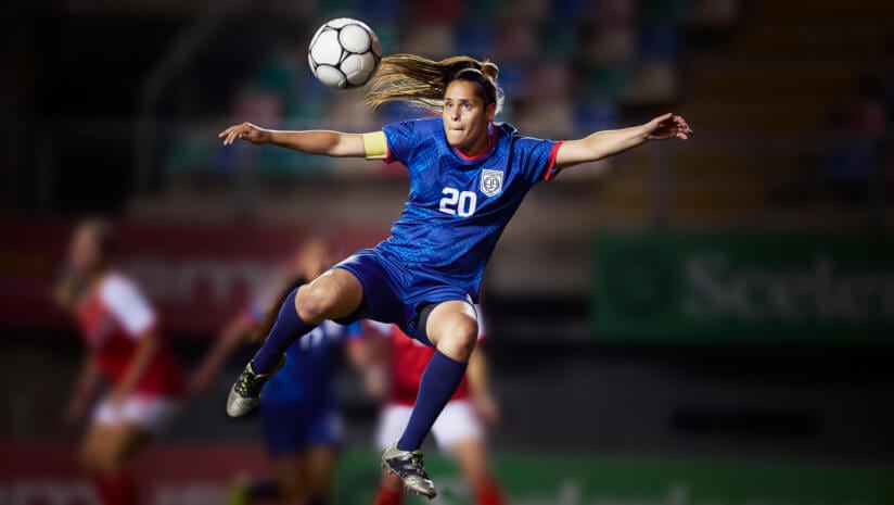 Soccer player in the air jumping to kick a ball