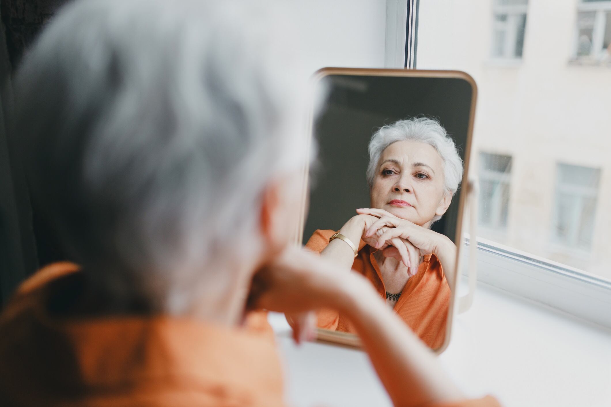 Mature woman looking at herself in mirror