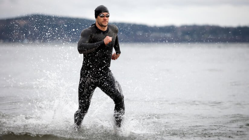 Photo of a triathlete running through the water