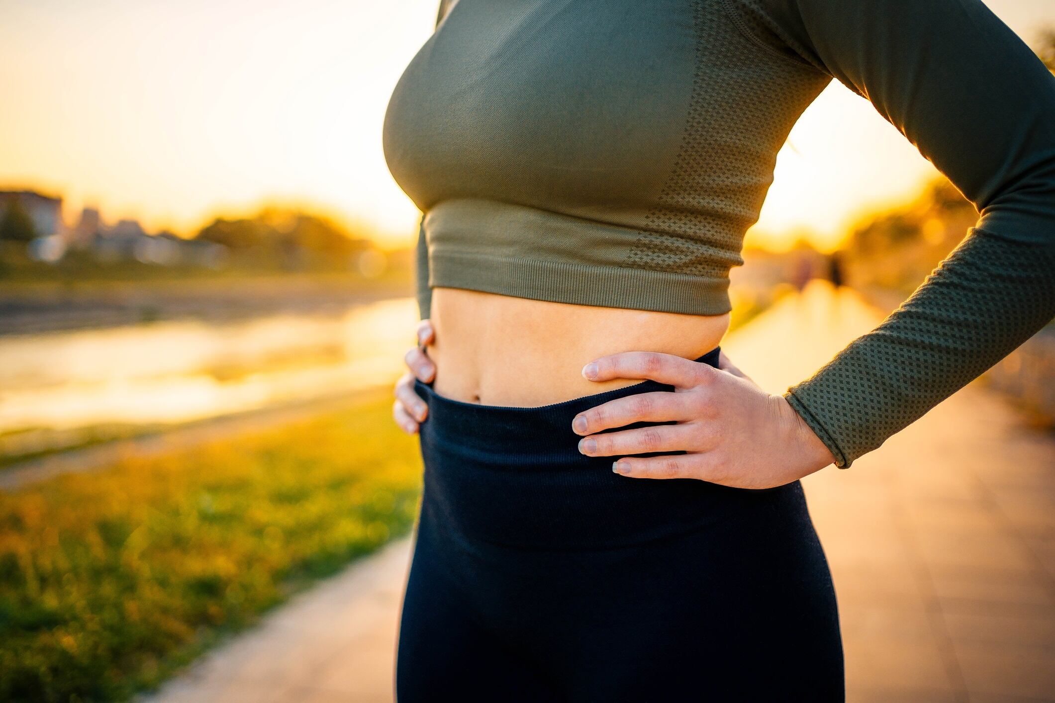 Close-up body of a fit woman in sports clothing outdoors