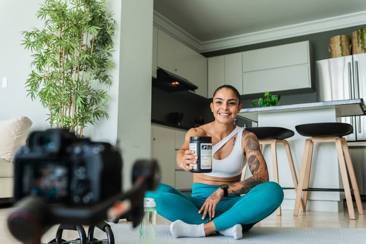 Woman influencer recording vlog talk about protein supplement