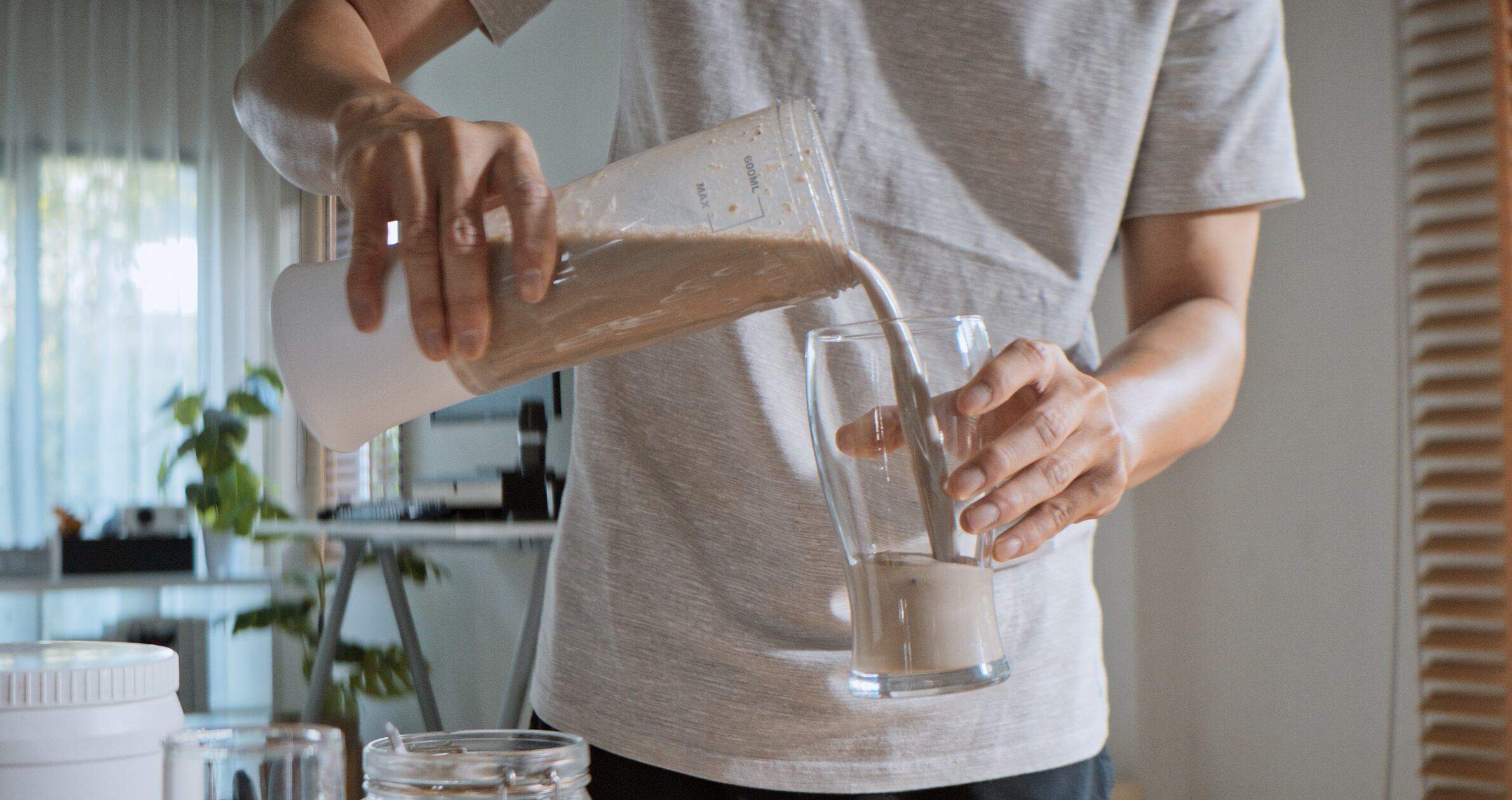 Young adult Asian man prepare and make protein shake drink, mixed fruit cereal juice, using blender mixer. Fitness dietary activity, healthy diet lifestyle, health care nutrition concept