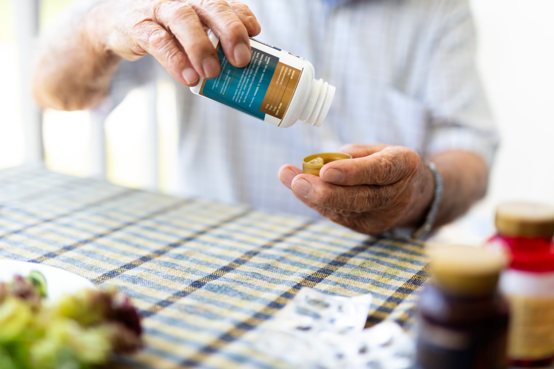 And elderly man takes a vitamin supplement.