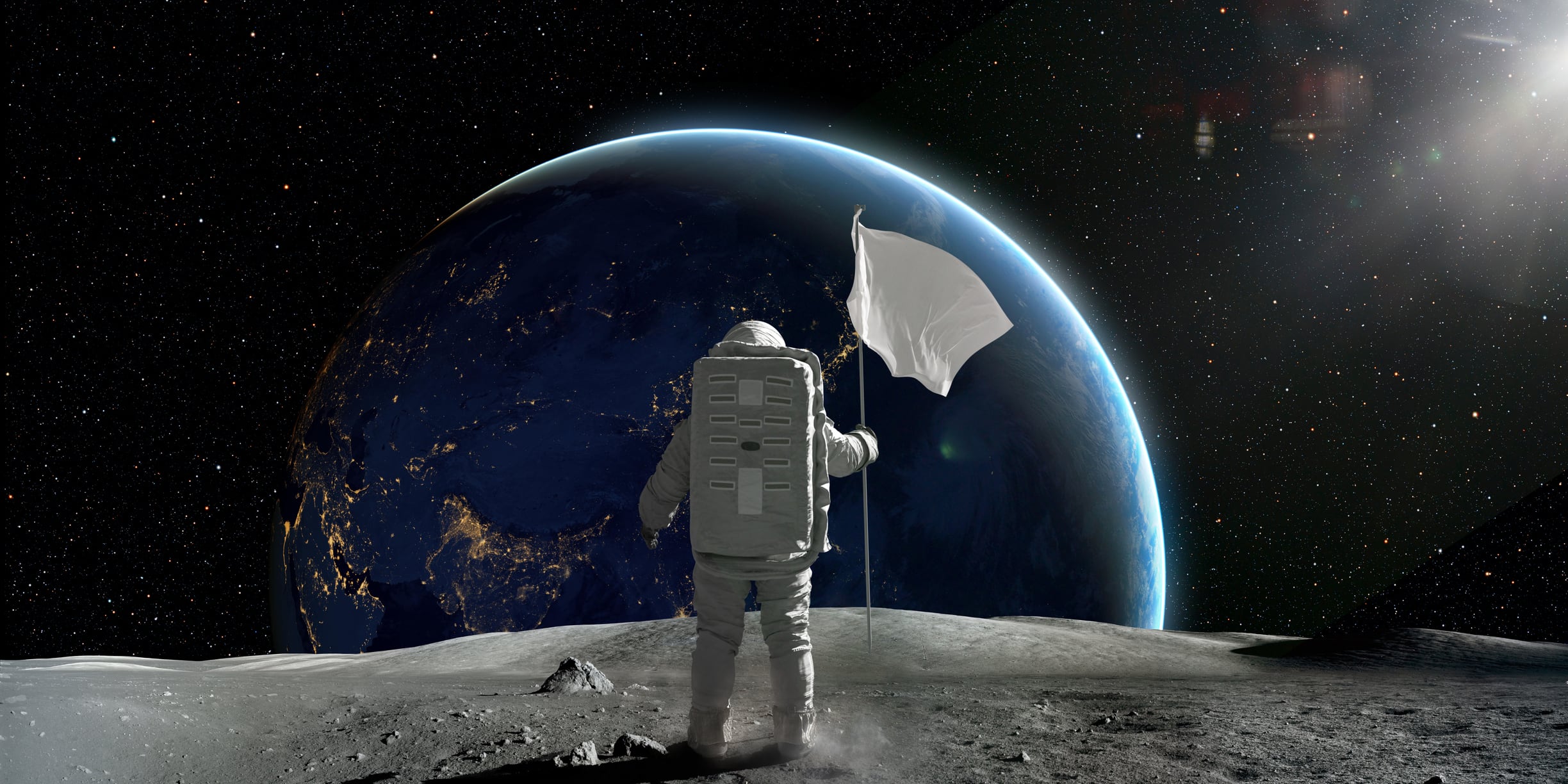 Rear view of an astronaut in full space suit and backpack on surface of the moon, holding a white flag on pole, looking at a distant planet Earth. Earth Image Nasa: