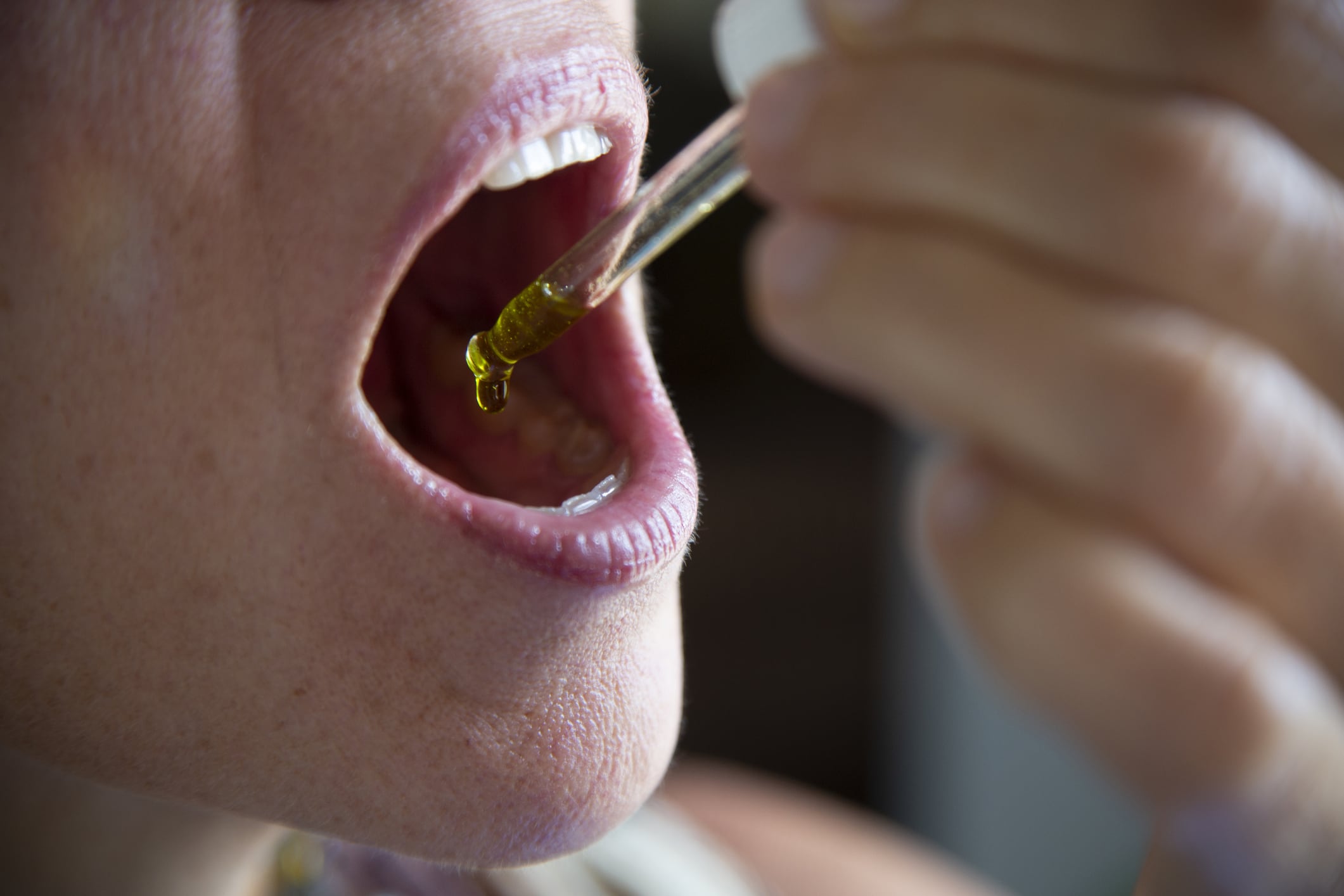 Self medication of CBD oil using an eye dropper under the tongue.