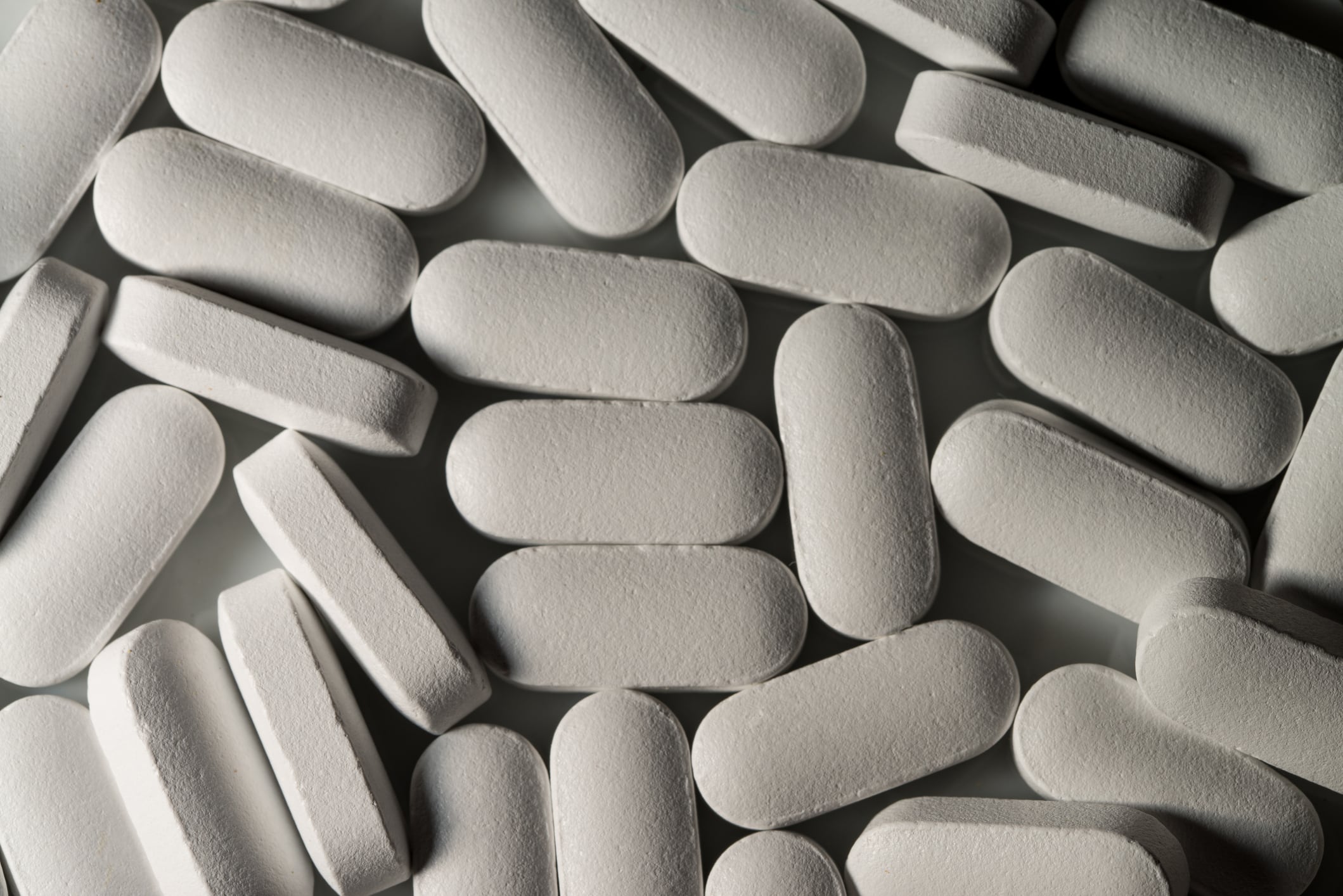 White magnesium pills spread out on s white background