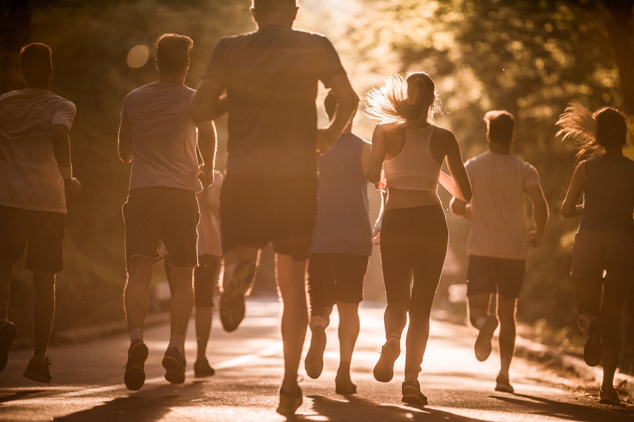 Rear view of large group of athletes having a marathon race in nature.