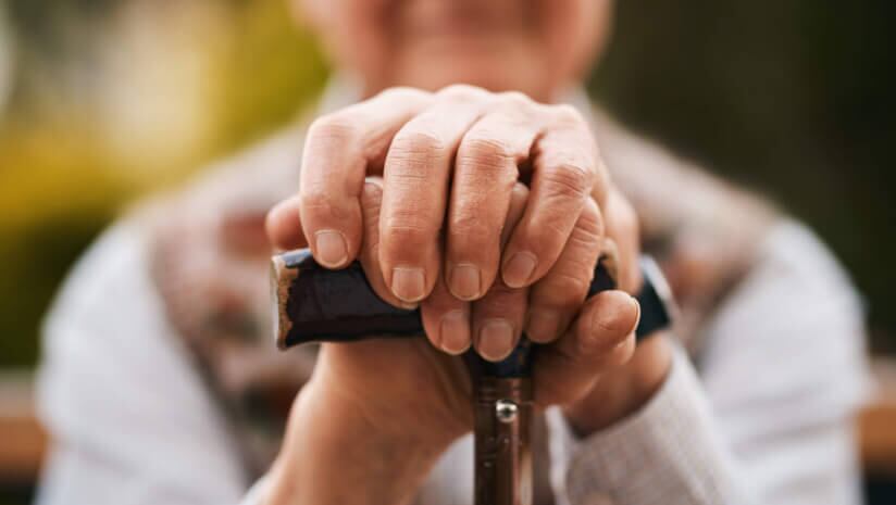 Older person holding onto a cane