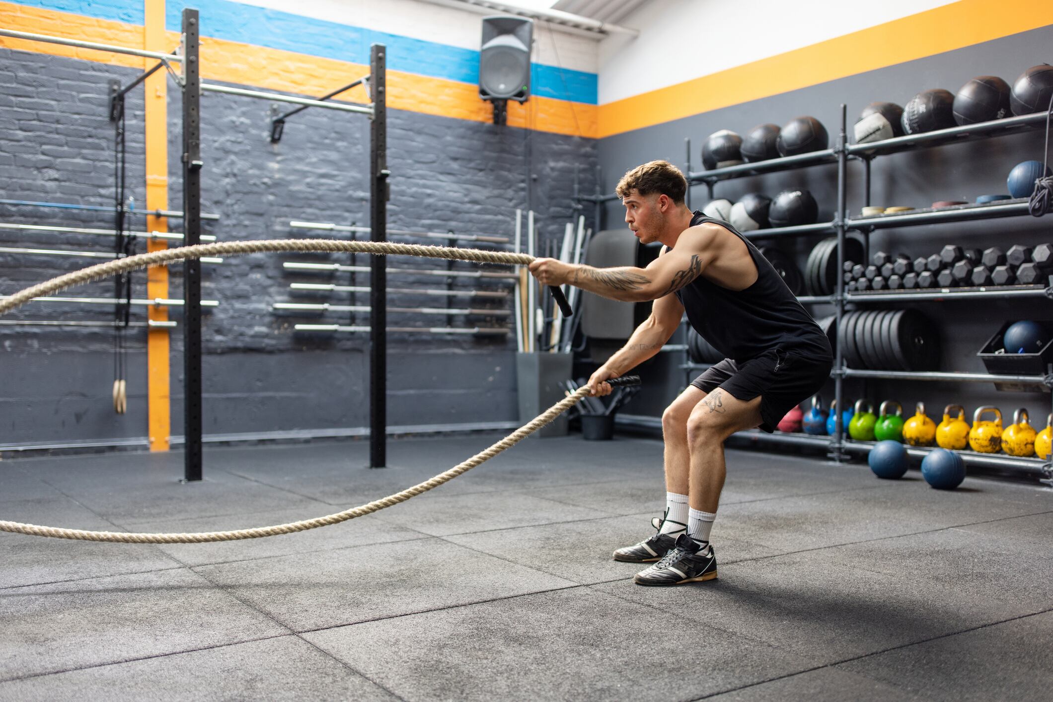 Fitness man working out with battle ropes at the gym. Healthy young man using battle ropes for cross training.