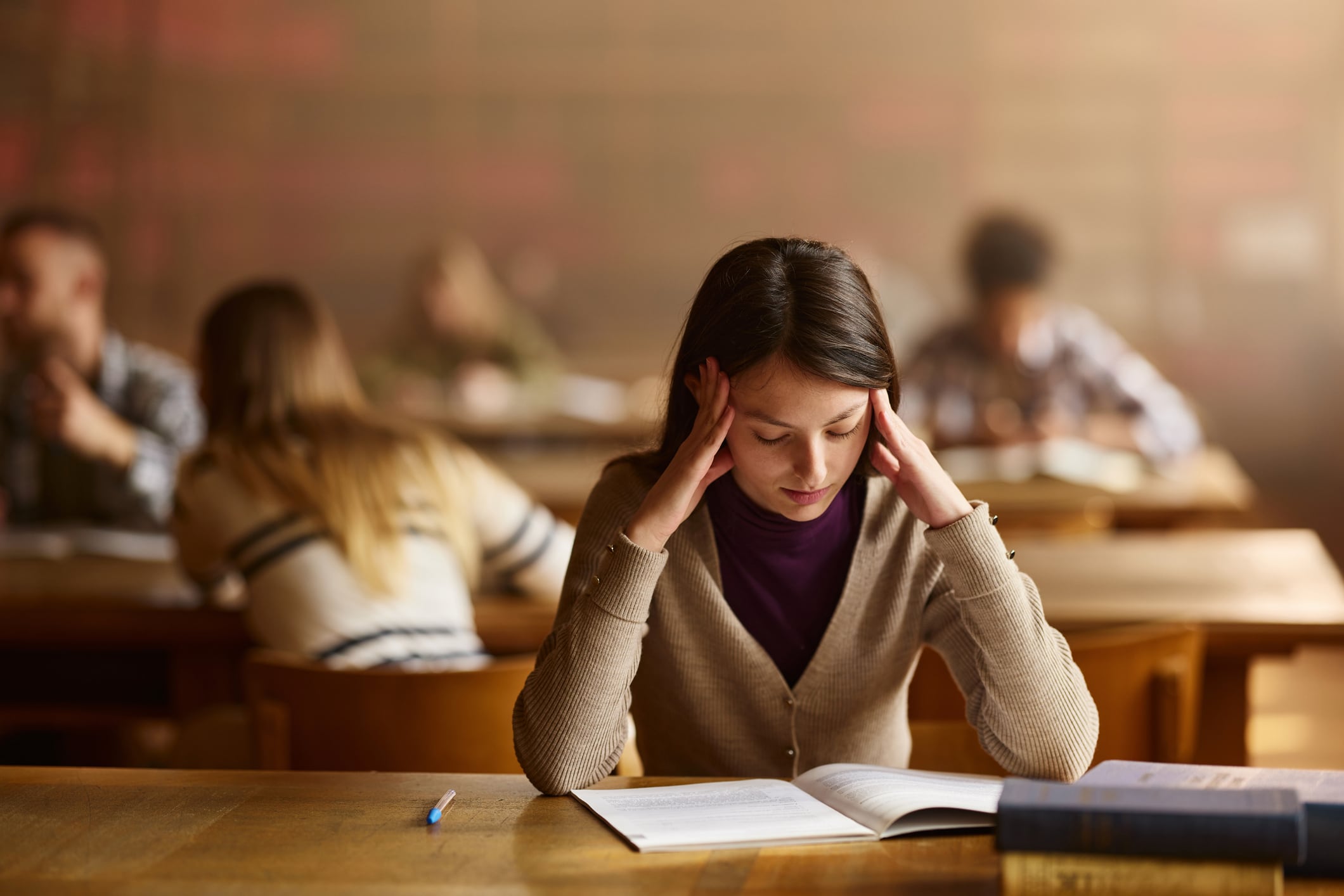 Post-graduate student is stressed and tired studying in library