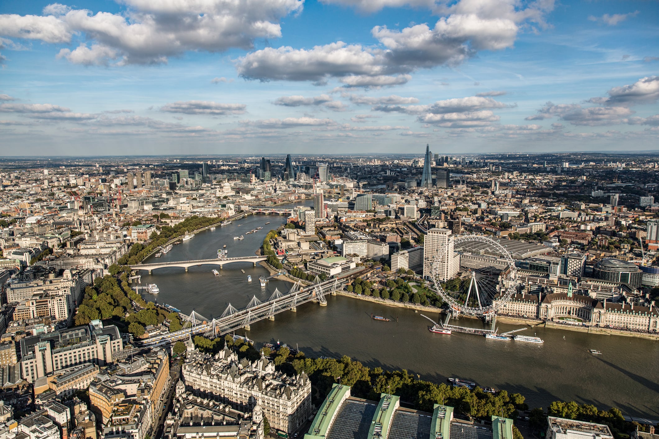 Aerial view of London Eye on the River Thames with London's skyline in background including Waterloo Bridge, The Shard and the Financial District