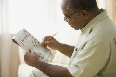 Older man doing a crossword puzzle   Image © Jose Luis Pelaez Inc / Getty Images